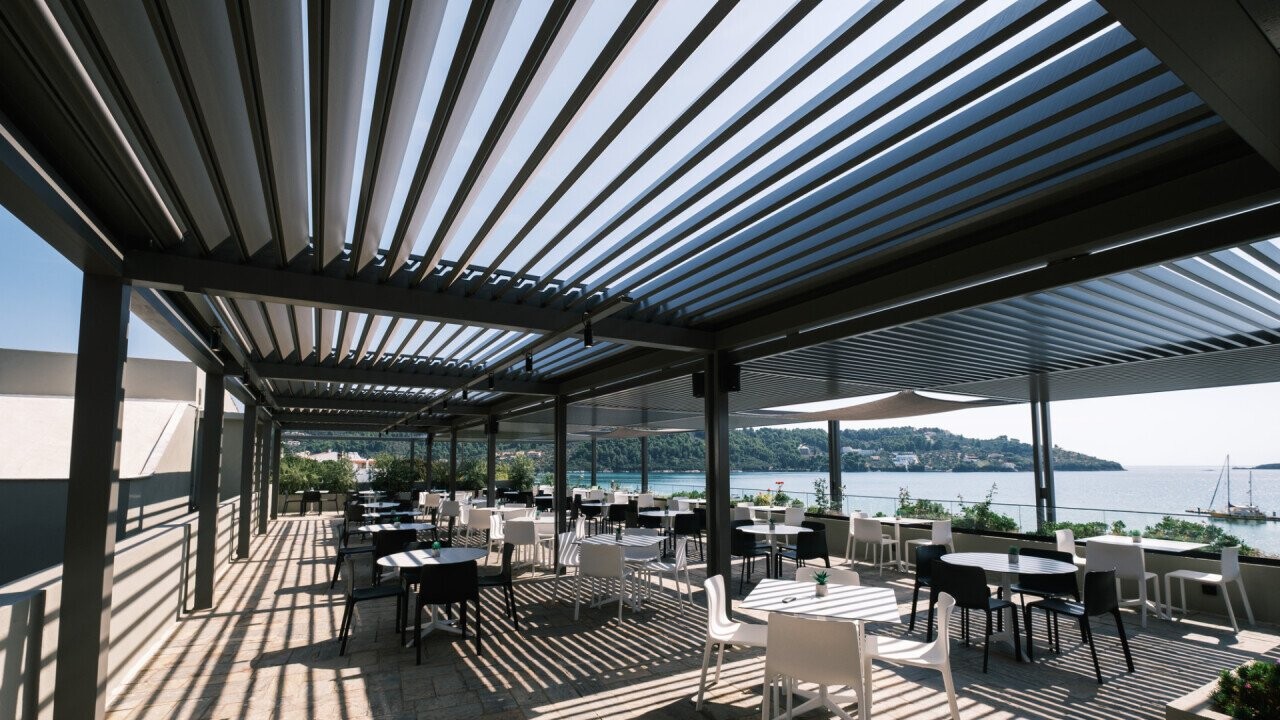 An impressive view of the endless sea merges with an expansive guest garden, becoming even more versatile through a sophisticated louvered roof. The generous space not only provides a breathtaking backdrop but, thanks to the louvered roof, allows for flexible use — be it for sunny lunches, relaxed evenings, or protected events. Enjoy the freedom and elegance of this extraordinary seaside location.