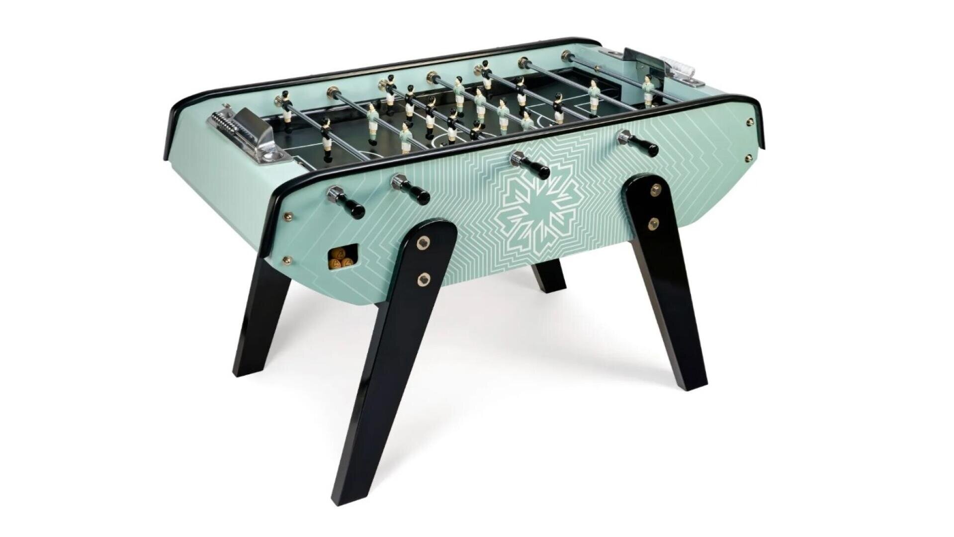 A light green foosball table with black, angled legs, a geometric pattern on the sides and metal bars with miniature football players.