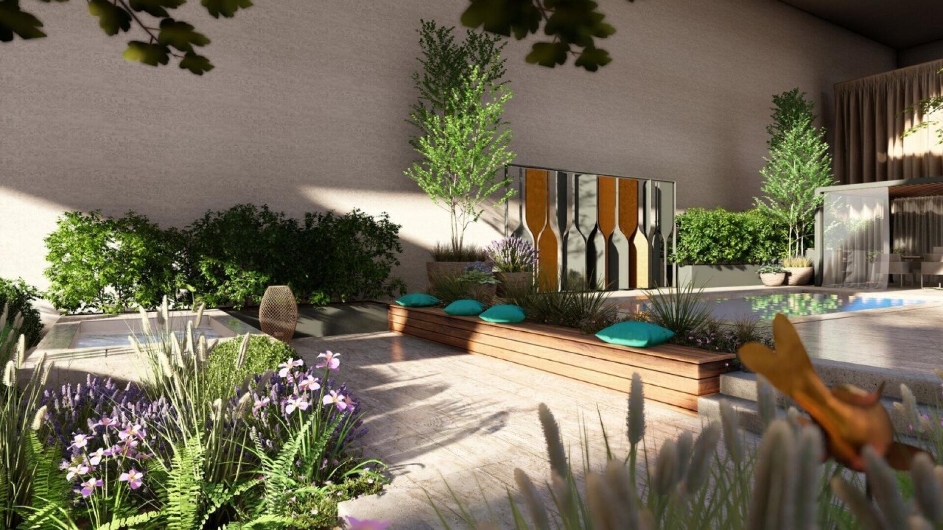 A modern outdoor patio with wooden benches, turquoise cushions, lush green plants, flowering bushes, trees, and a small pool next to a decorative wall and shaded seating area. Sunlight casts natural shadows.