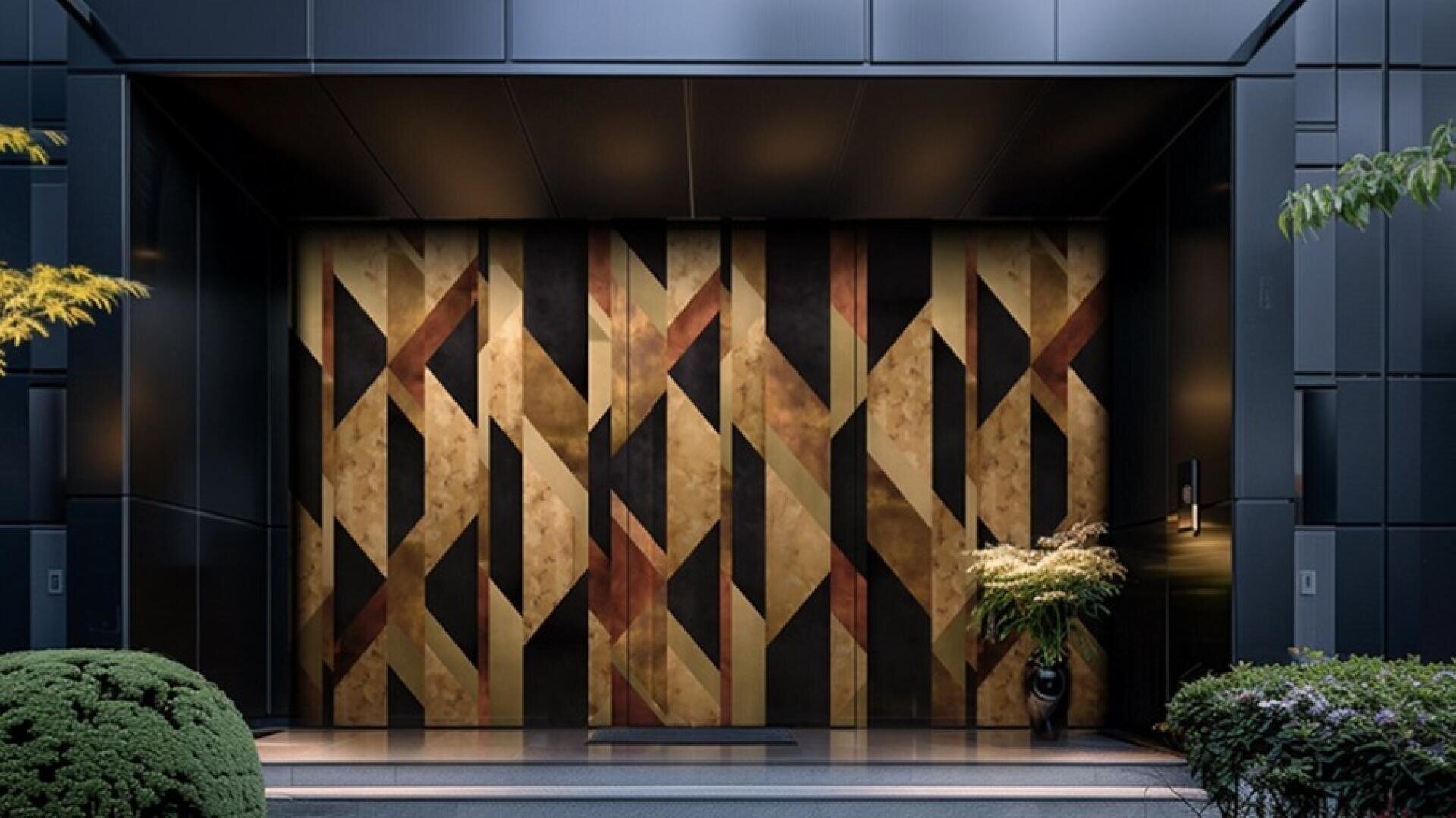 A modern entrance with large, geometrically patterned double doors in gold and bronze tones, framed by dark walls. Green shrubs and potted plants adorn the area and add a touch of nature to the simple design.