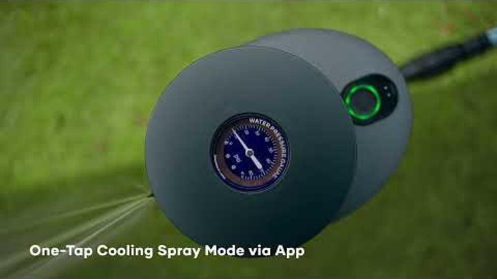 Close-up of a circular device with a pressure gauge at the top that sprays water. The background is grassy and the words "One-Tap Cooling Spray Mode via App" are written in white at the bottom.