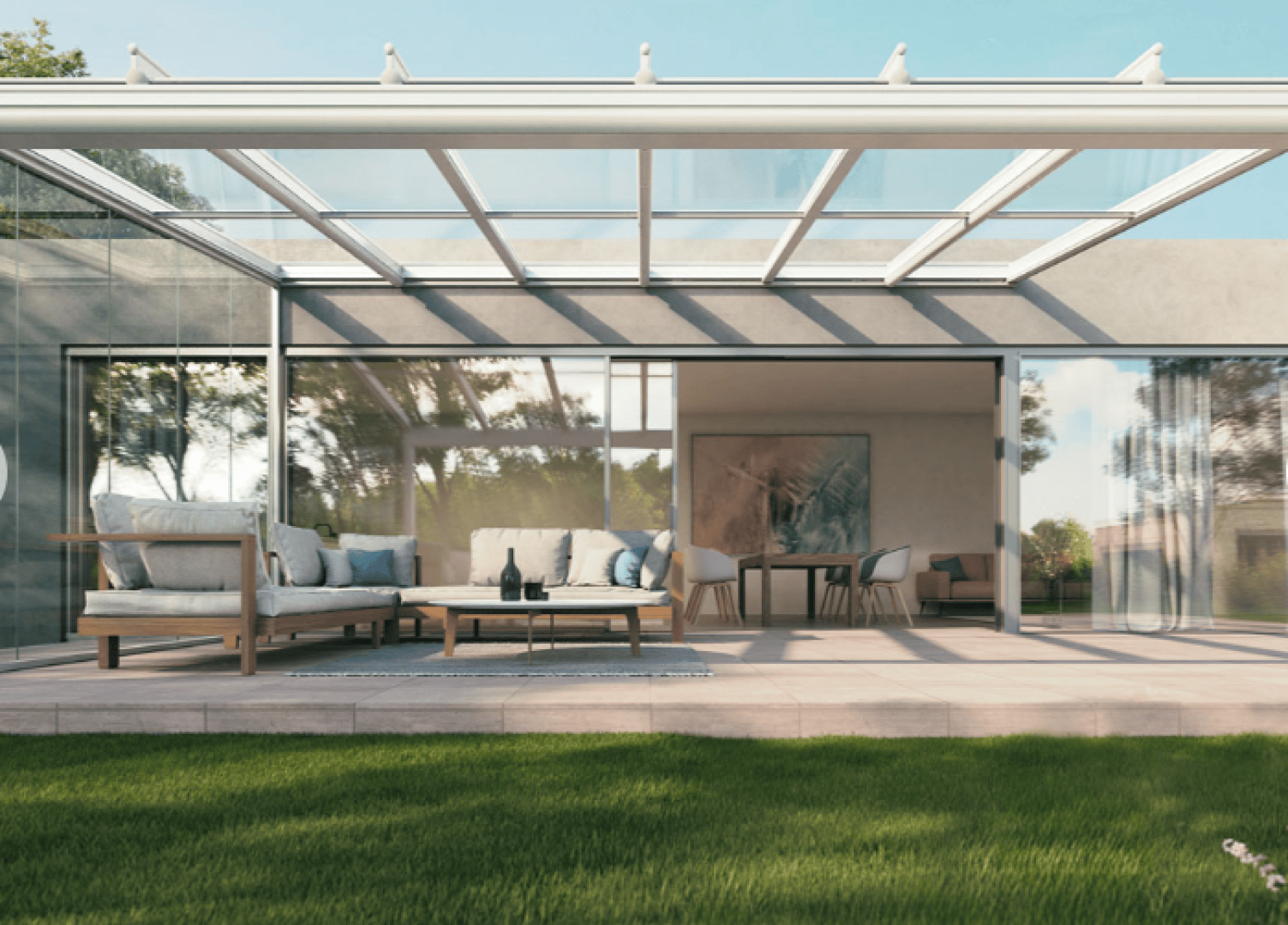 A modern house with large glass sliding doors, an outdoor patio with cushioned seating, a clear roof, and a view of a dining area inside. The space opens onto a green lawn under a blue sky.