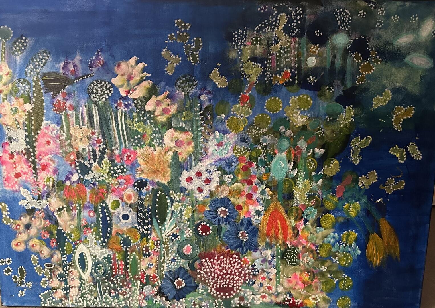 Ein lebhaftes abstraktes Gemälde mit bunten, skurrilen Blumen und Pflanzen mit gepunkteten Mustern vor einem tiefblauen Hintergrund. Die Komposition ist dicht und lebendig, mit einer Mischung aus Grün-, Rosa-, Gelb- und Rottönen.