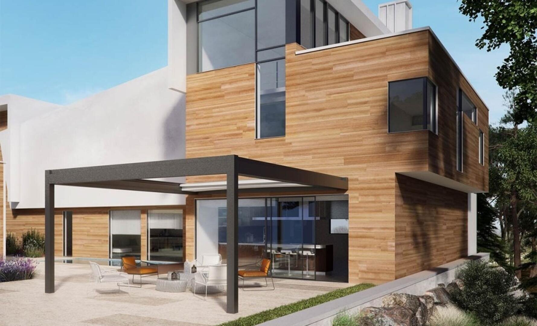 Modern two-story house with wood panel exterior and large windows. A black pergola shades a patio furnished with white chairs and a table. The landscaping includes rocks, trees, and small plants.