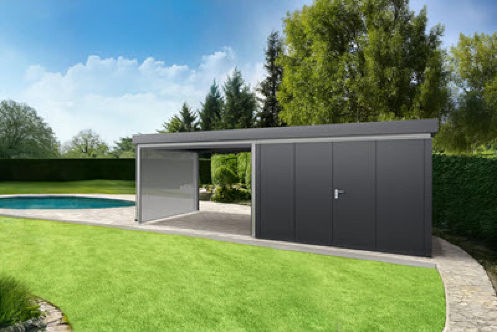 A modern, dark gray garden house with a closed door and an open sliding door stands on a stone terrace next to a curved swimming pool, surrounded by green grass, trees and hedges under a blue sky.