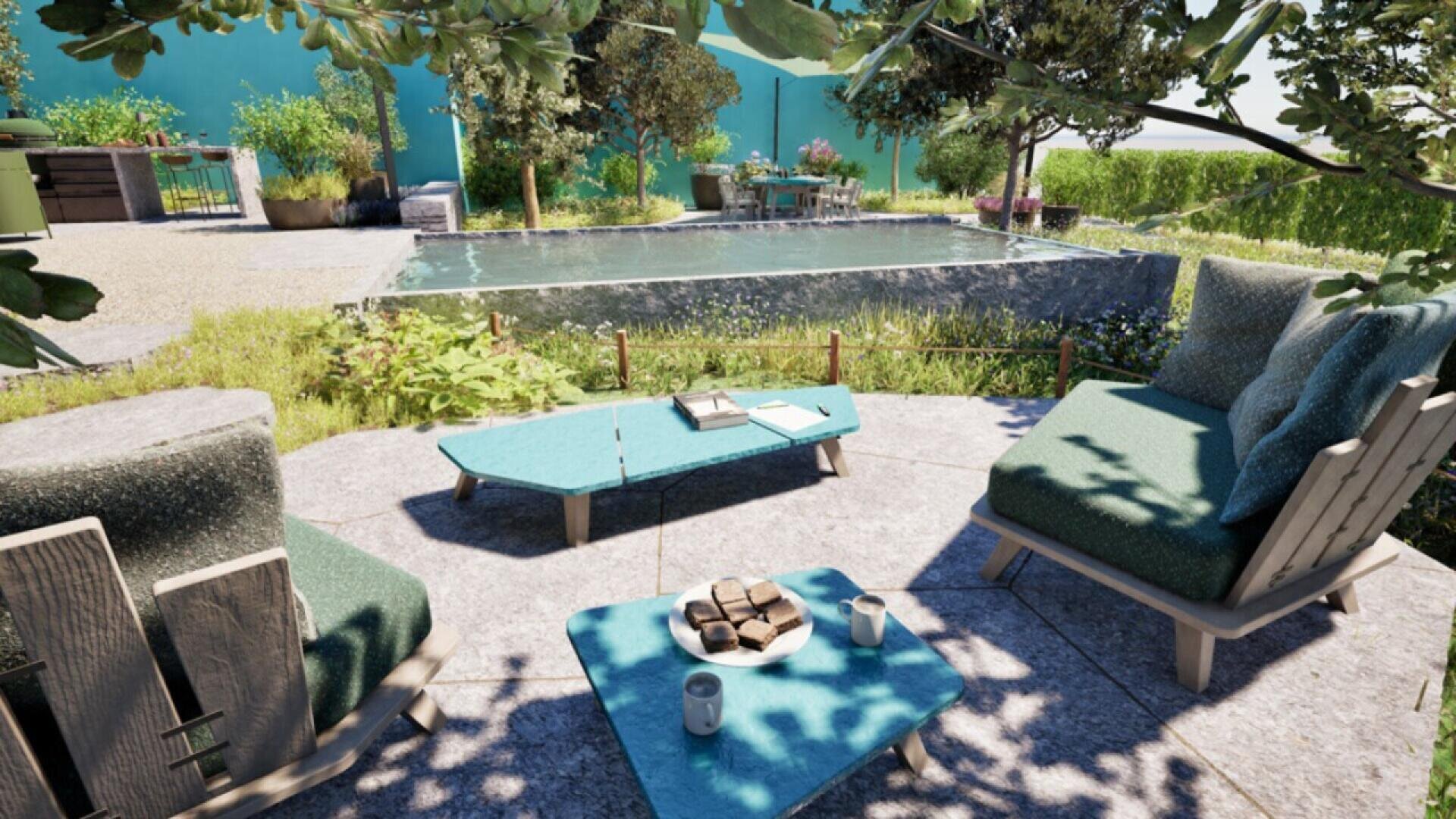 A cozy outdoor patio with cushioned chairs and a coffee table set with drinks and snacks, overlooking a tranquil pond and garden with tables, lush greenery, and trees in the background.