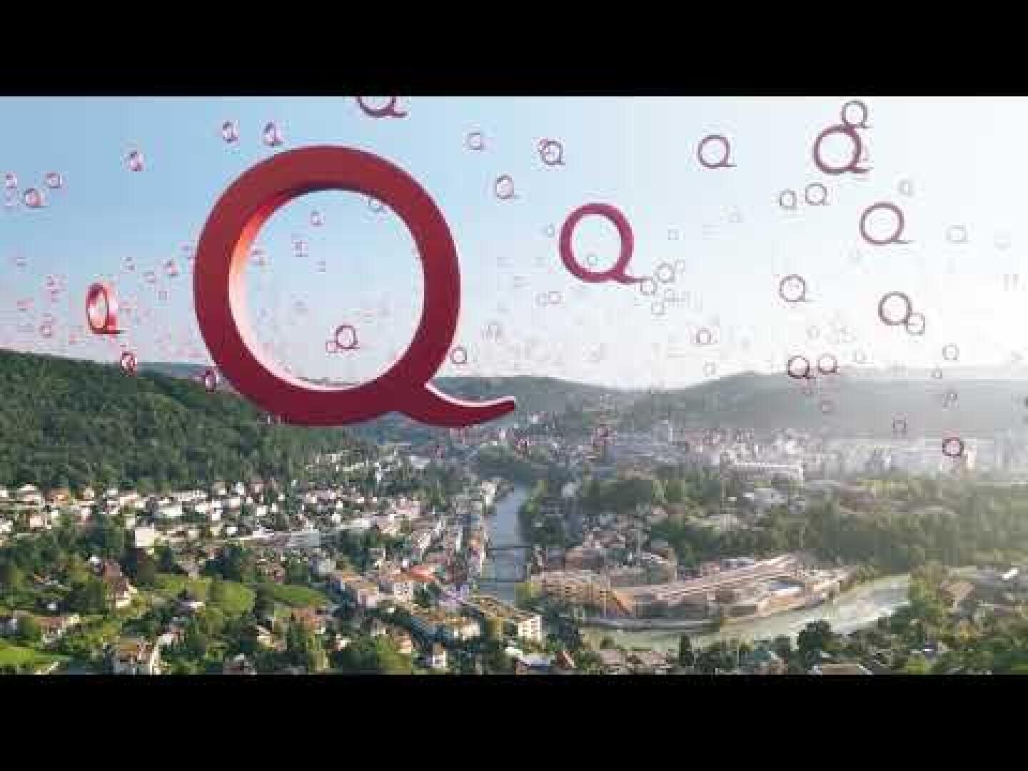 Eine Stadtlandschaft mit grünen Hügeln, einem Fluss und Gebäuden unter einem hellen Himmel, überlagert von vielen großen und kleinen roten Q-Grafiken, die über das Bild verteilt sind.