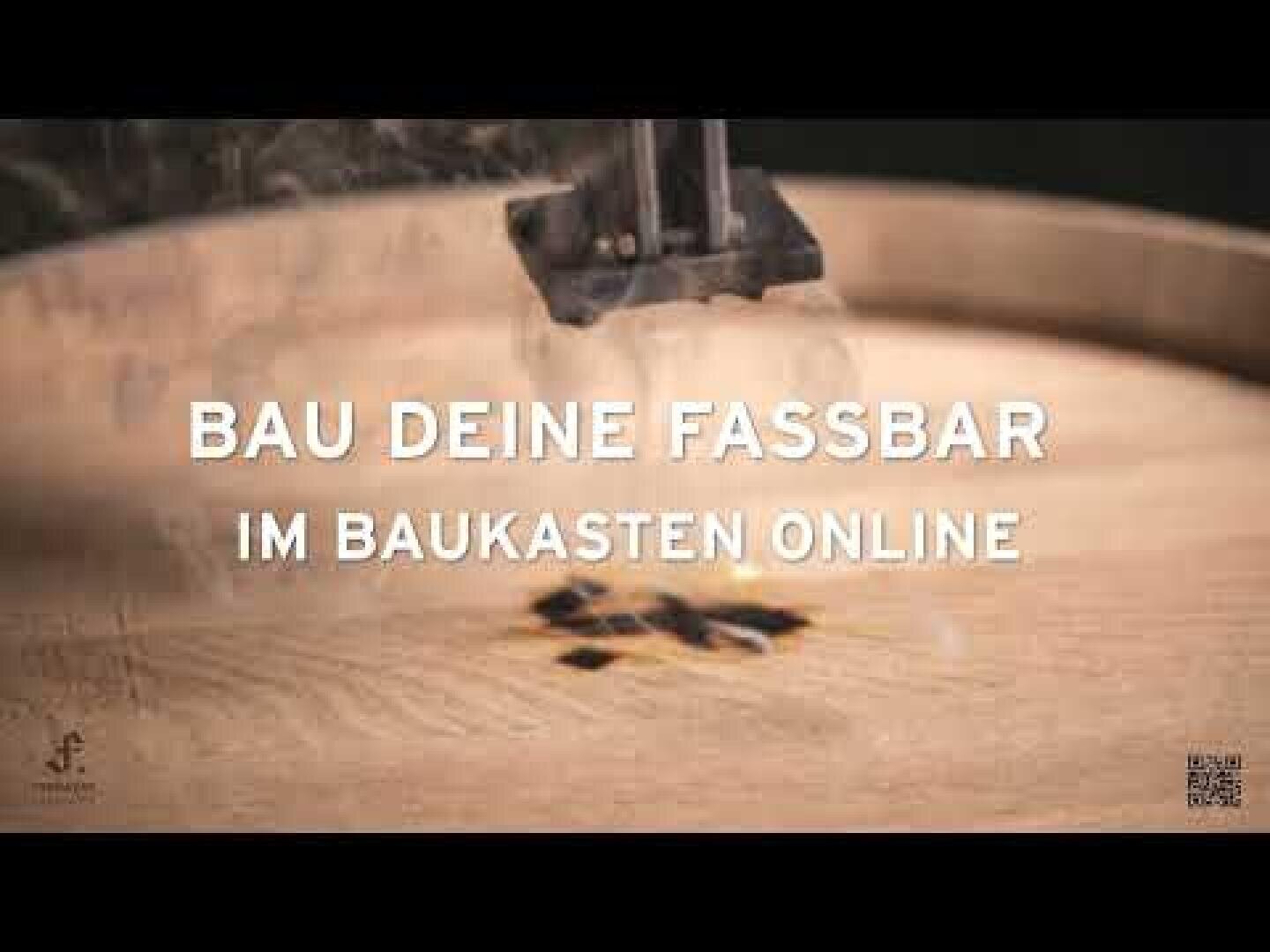 Close-up of a wooden barrel being branded with a hot iron, overlaid with the German text "BAU DEINE FASSBAR IM BAUKASTEN ONLINE.".