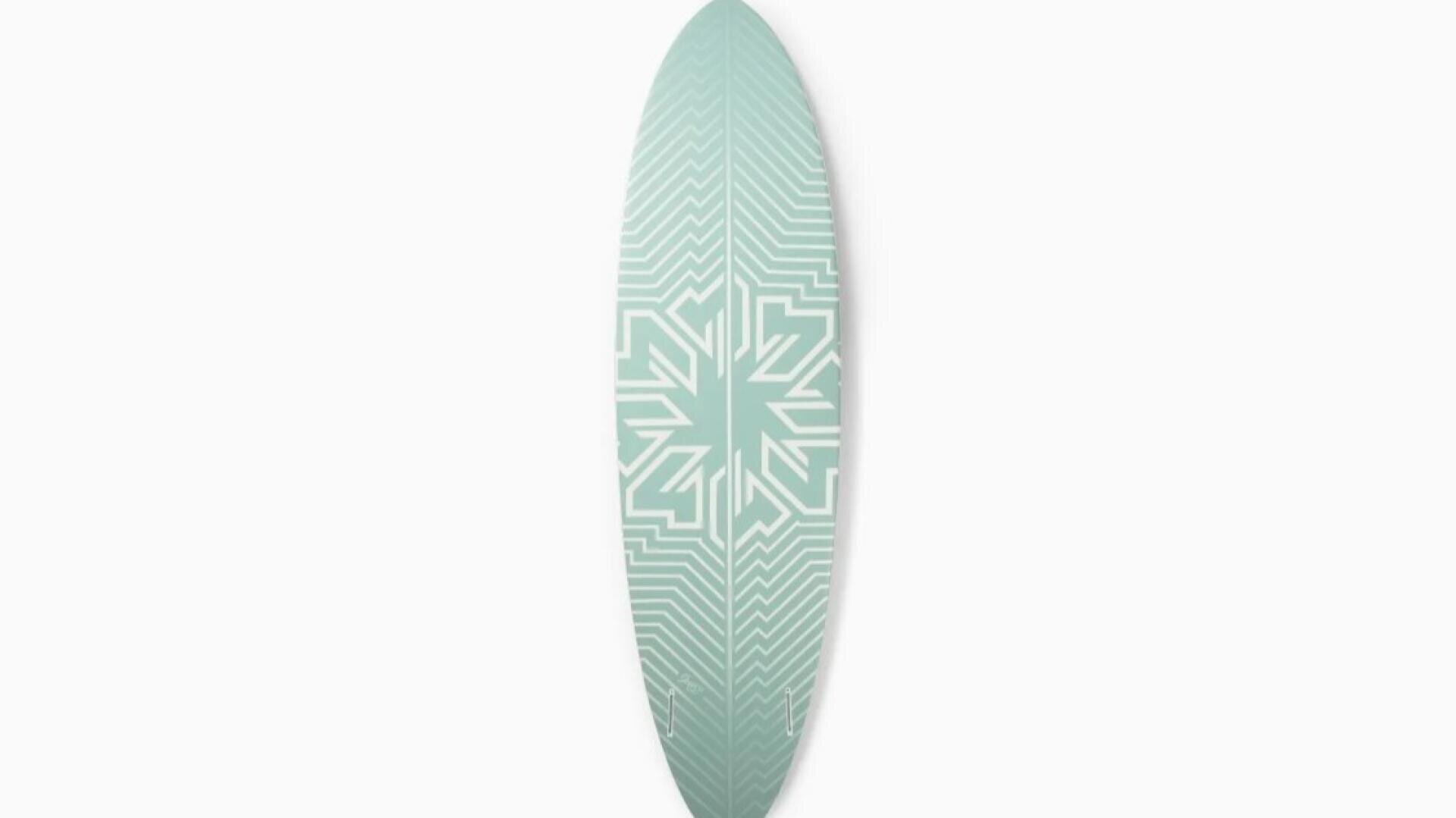 A pale green surfboard with a symmetrical, geometric white pattern in the center, displayed vertically against a white background.