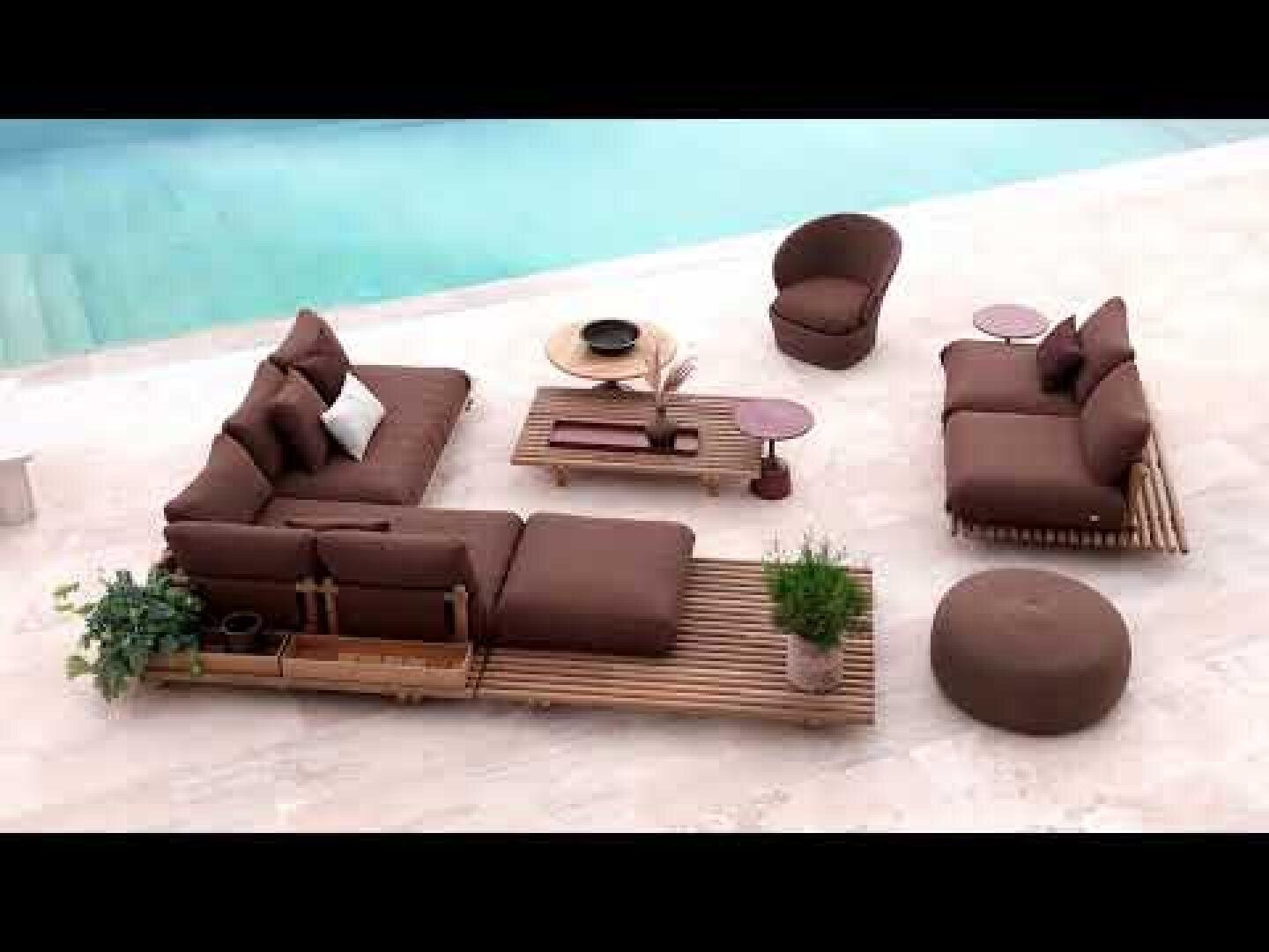 Moderne Sitzgruppe im Freien am Pool mit braunen gepolsterten Sofas, Sesseln, einer runden Ottomane, einem kleinen Beistelltisch, einem hölzernen Couchtisch und Topfpflanzen auf einer hellen Steinterrasse.