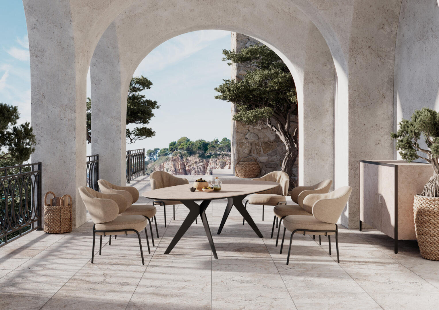A stylish outdoor terrace with a round dining table, six upholstered chairs, potted plants and stone arches overlooking a picturesque coastal landscape with trees and cliffs in the background.
