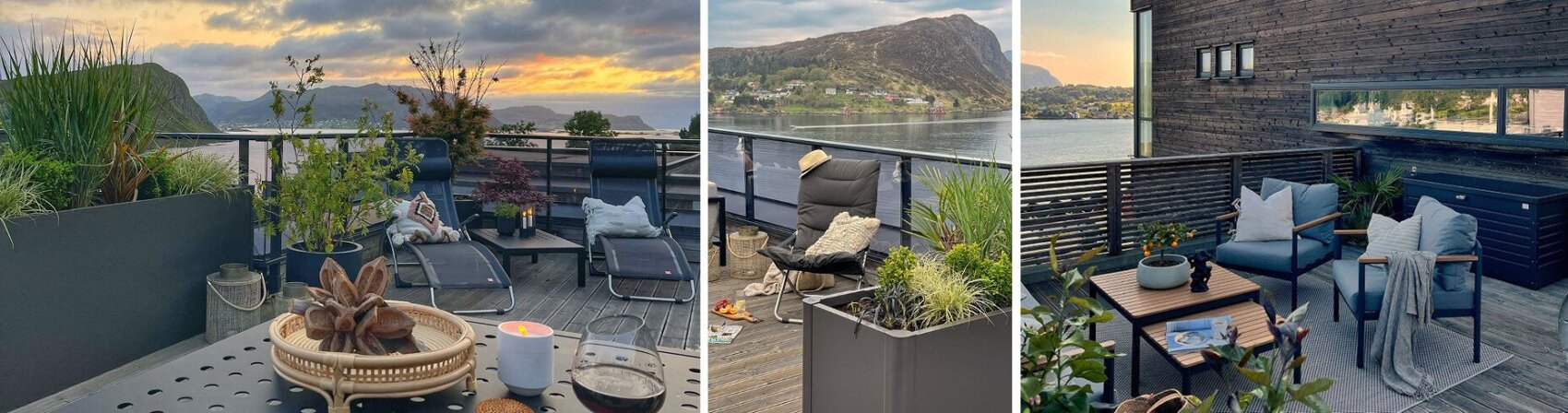 A rooftop terrace with lounge chairs, potted plants, and outdoor furniture overlooks scenic mountains, water, and a sunset sky.